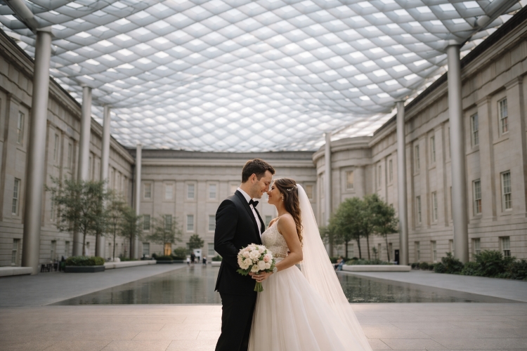 Couple standing under glass canopy at Kogod Courtyard Washington DC first look photo location