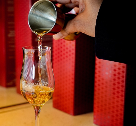 a person pouring liquid into a glass