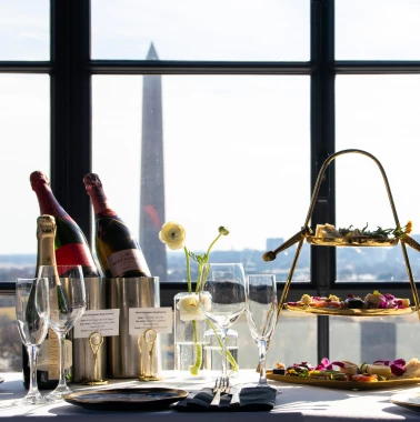 champagne afternoon tea setup at vue rooftop washington dc with tiered pastries and skyline views