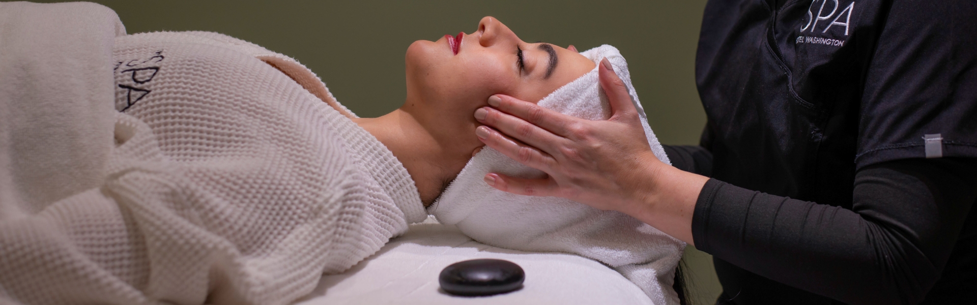 a woman lying down with her hands on her face