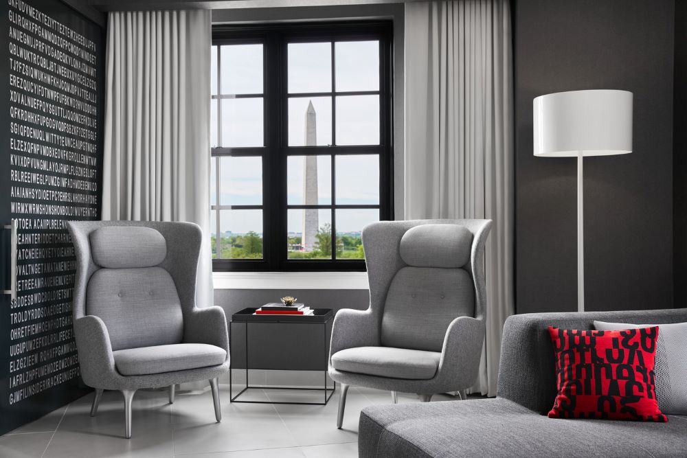 a room with grey chairs and a white lamp