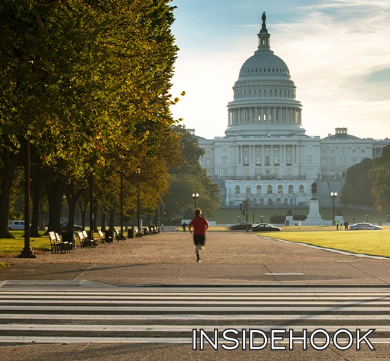 a person running on a sidewalk in front of a large white building