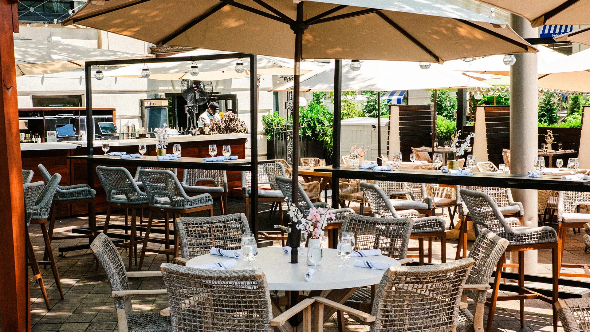 a tables and chairs outside with umbrellas