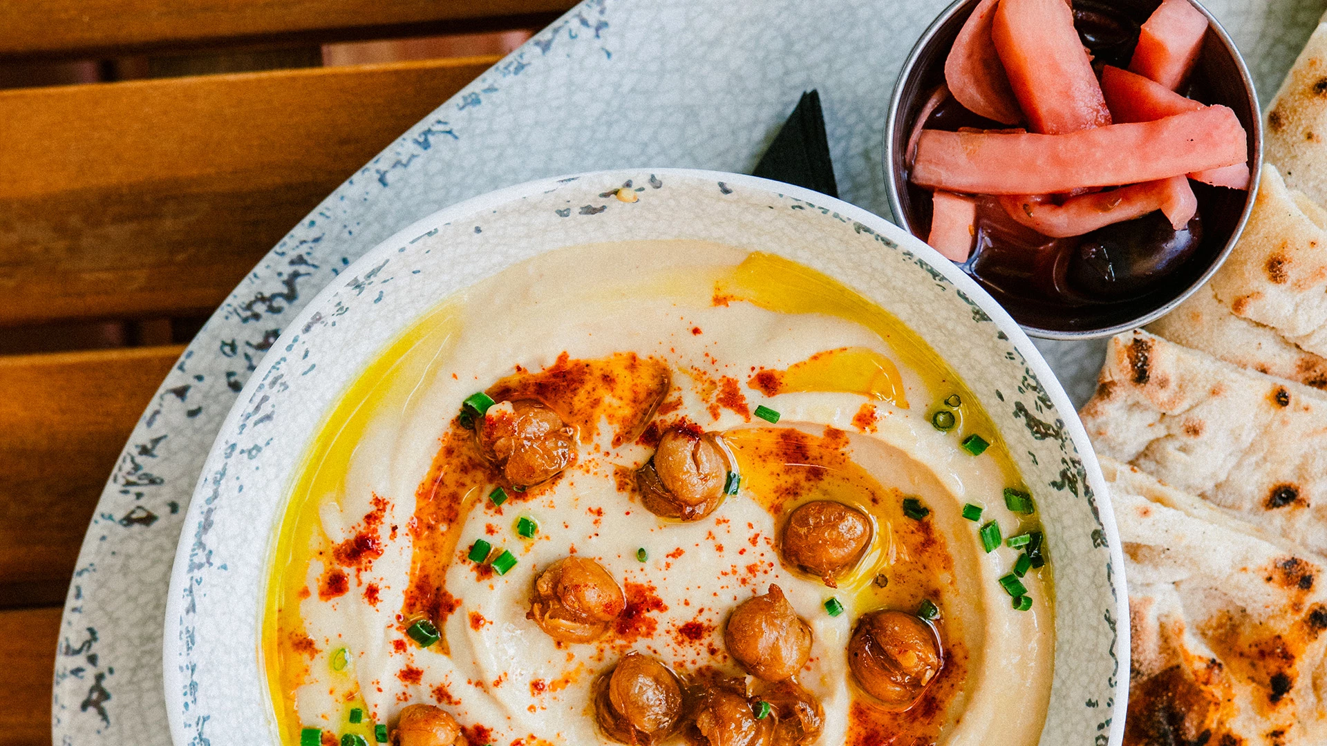 a bowl of hummus with vegetables and a bowl of food
