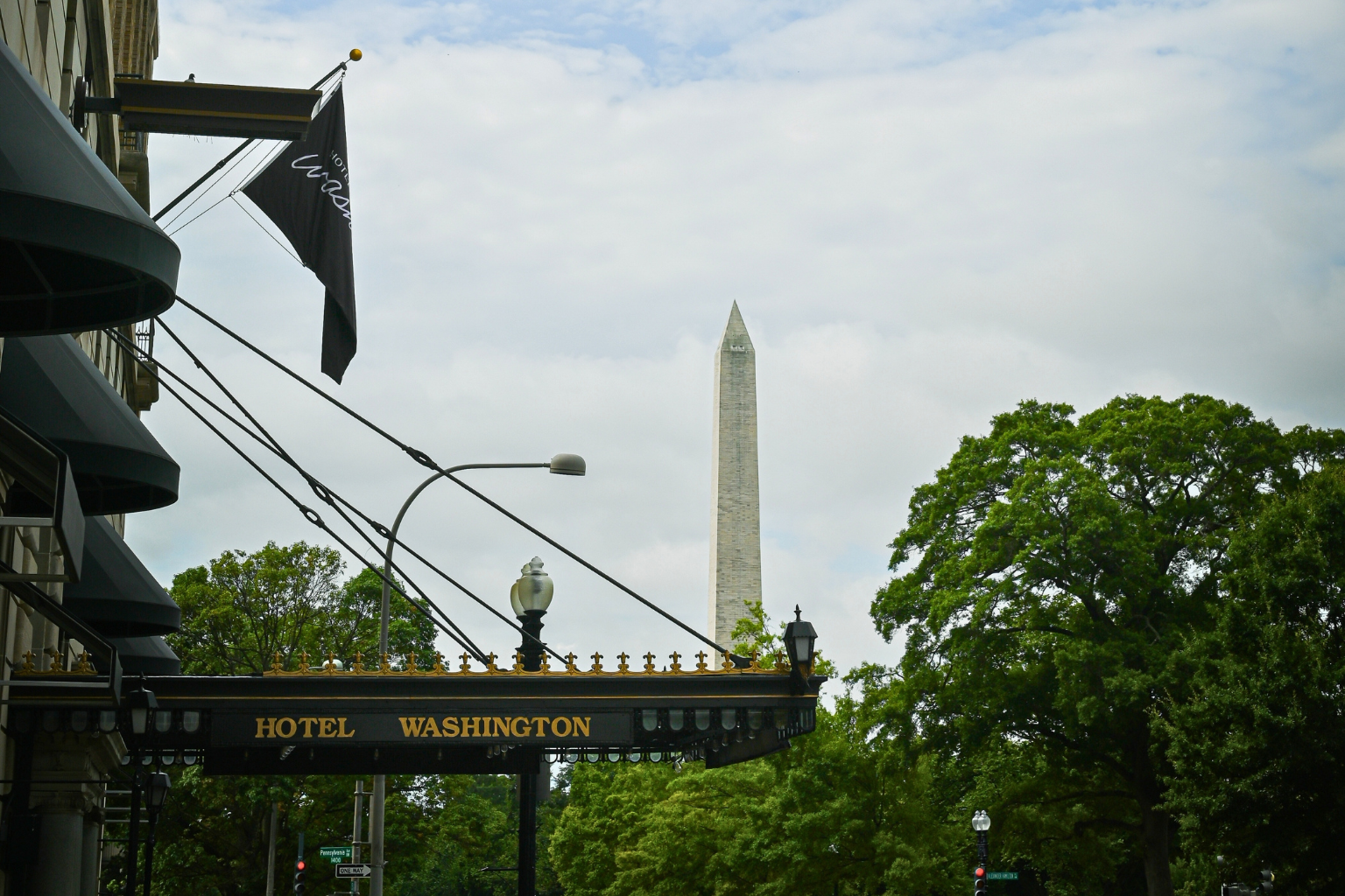 a sign with a flag and a monument in the background