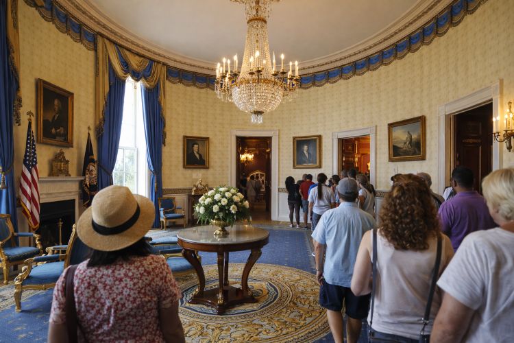 Interior of White House Blue Room during public tour with historic furnishings and chandeliers