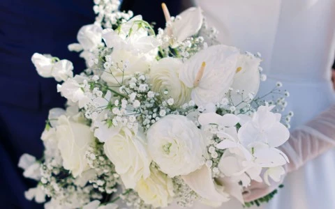 a bride and groom holding a bouquet of white flowers