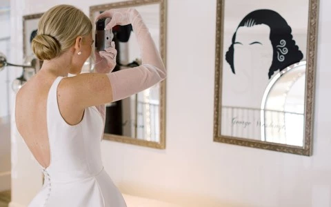 a woman in a white dress taking a picture of herself