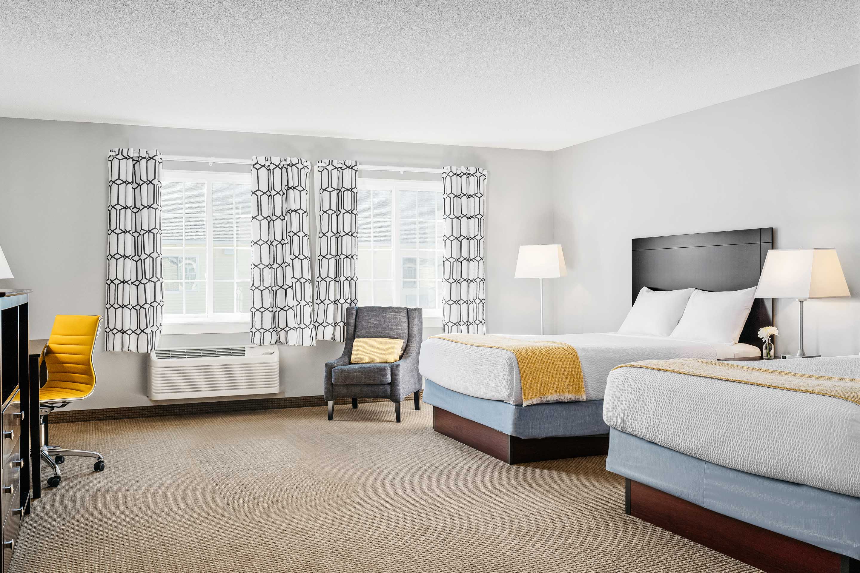 a room with two beds and a chair