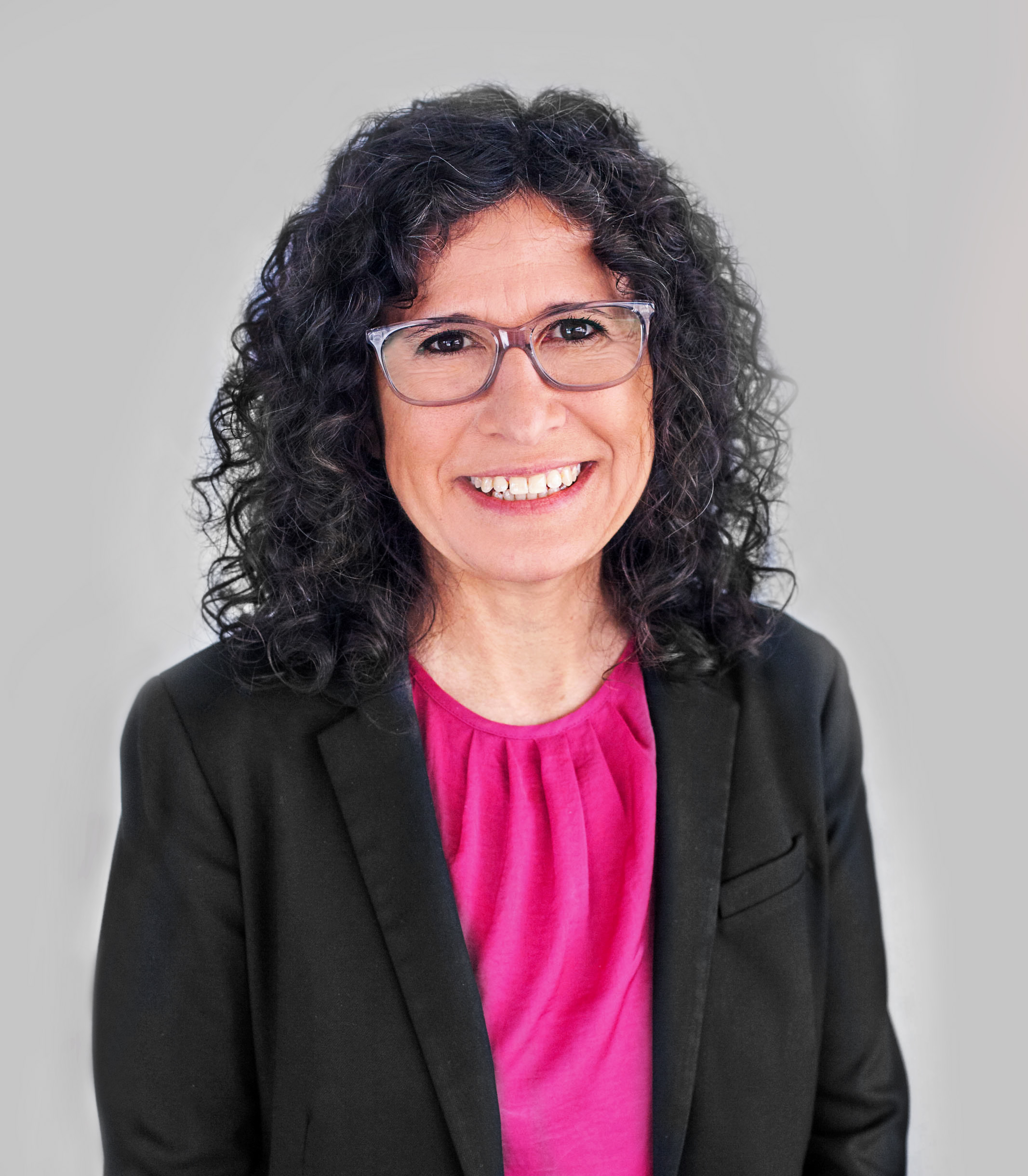 a woman wearing glasses and a black jacket