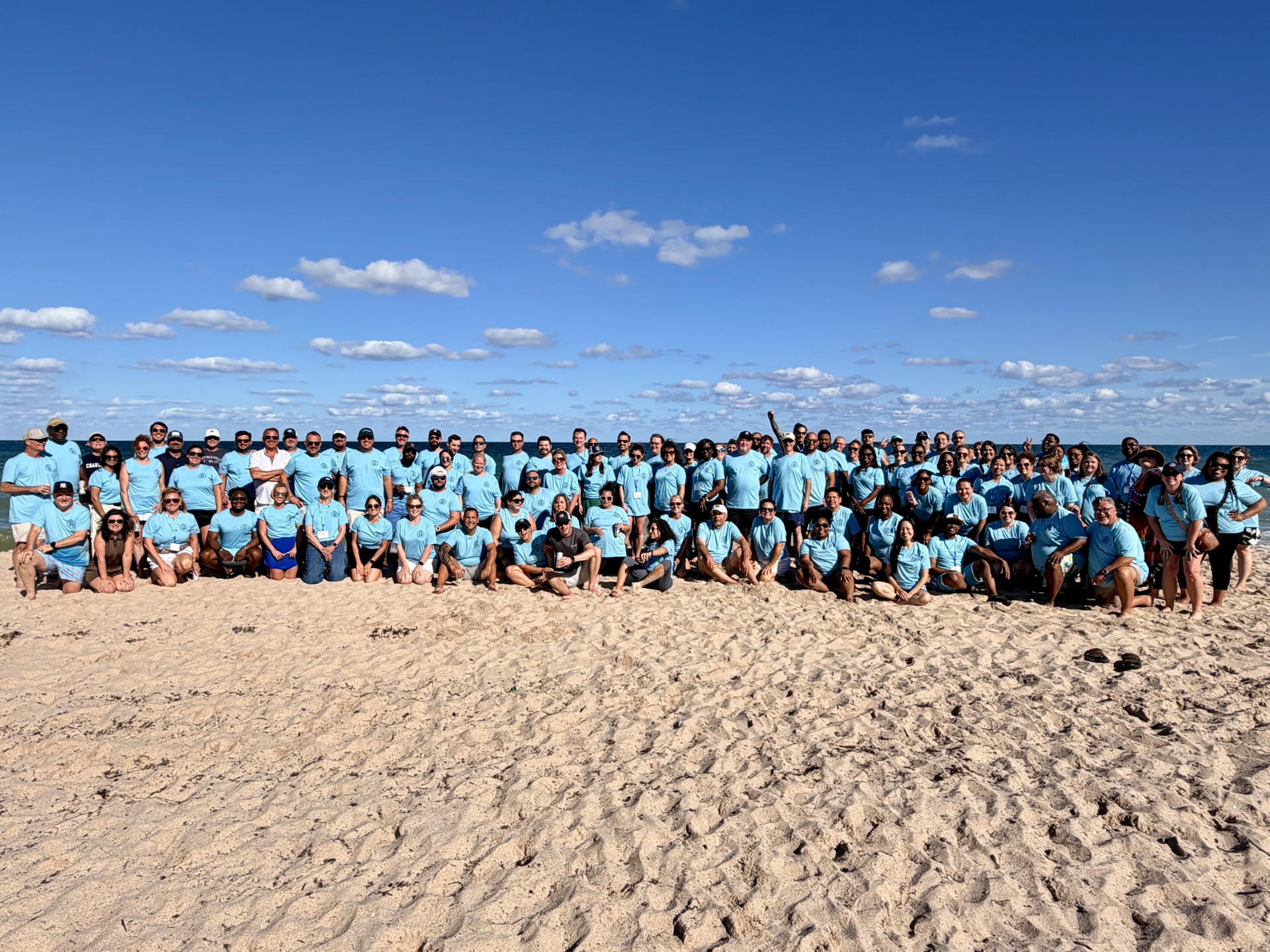 a group of people posing for a photo on a beach