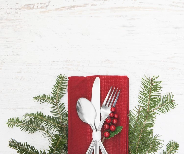 a silverware and a red napkin with a ribbon and berries