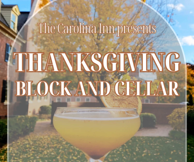 a glass of yellow liquid in front of a house