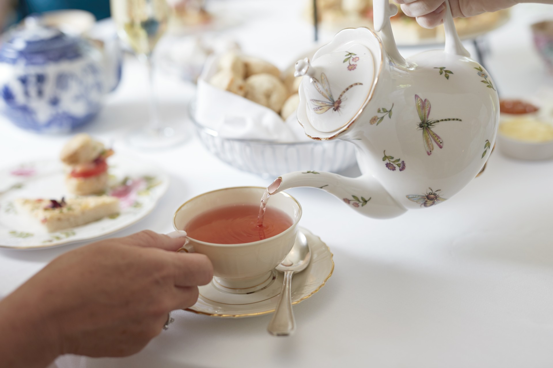 a person pouring tea into a cup