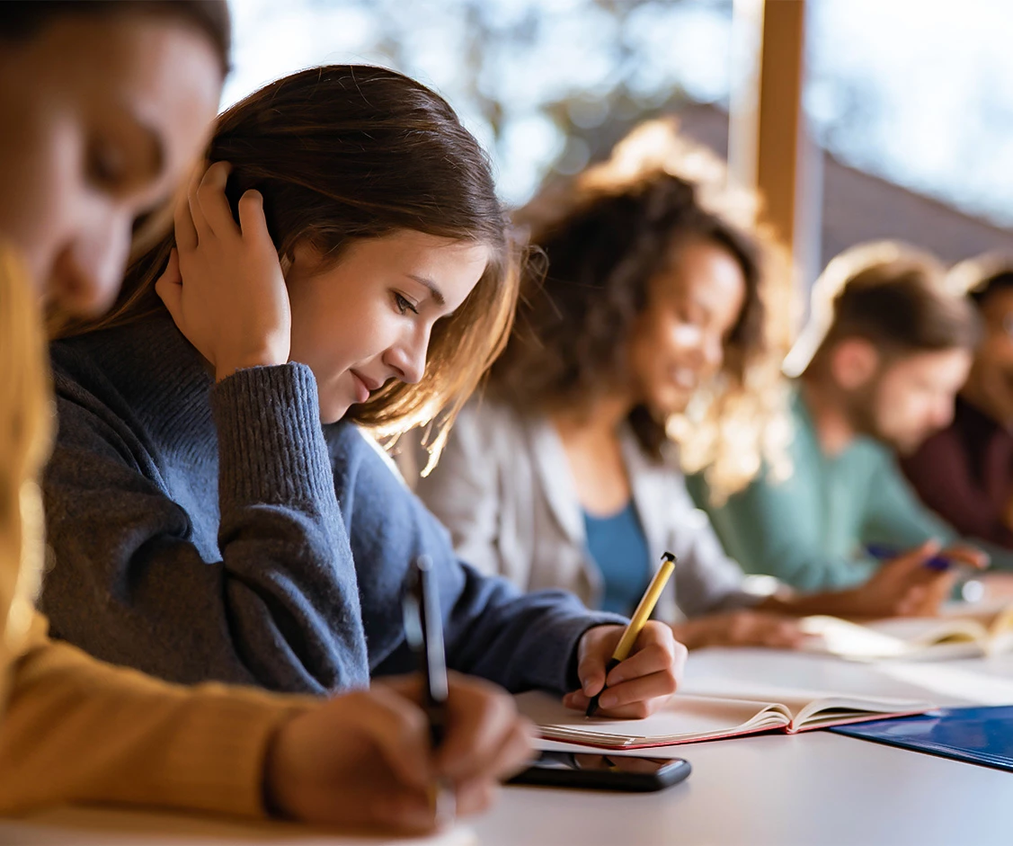 a group of people writing on a table
