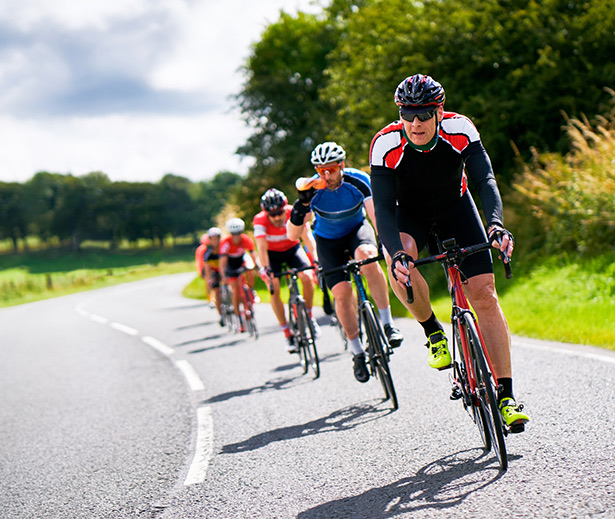 a group of people riding bicycles on a road