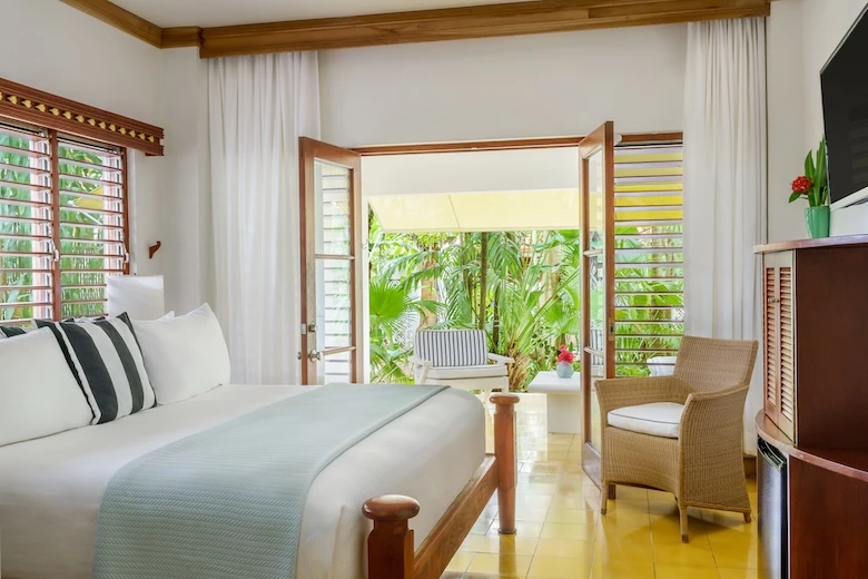 a room with a bed and chairs