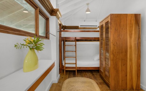 a room with bunk beds and a wood cabinet