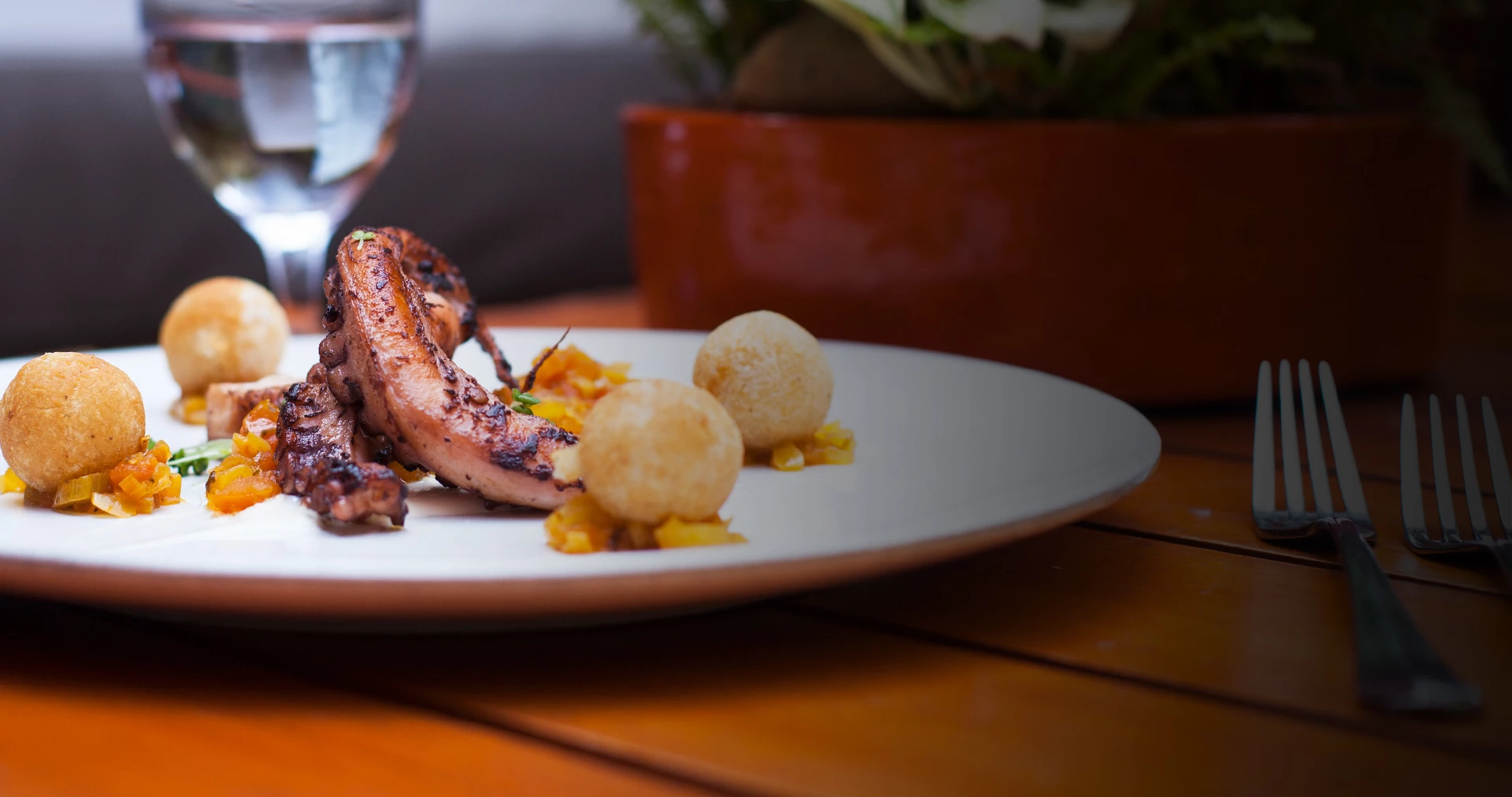 Grilled octopus served on large white platter.