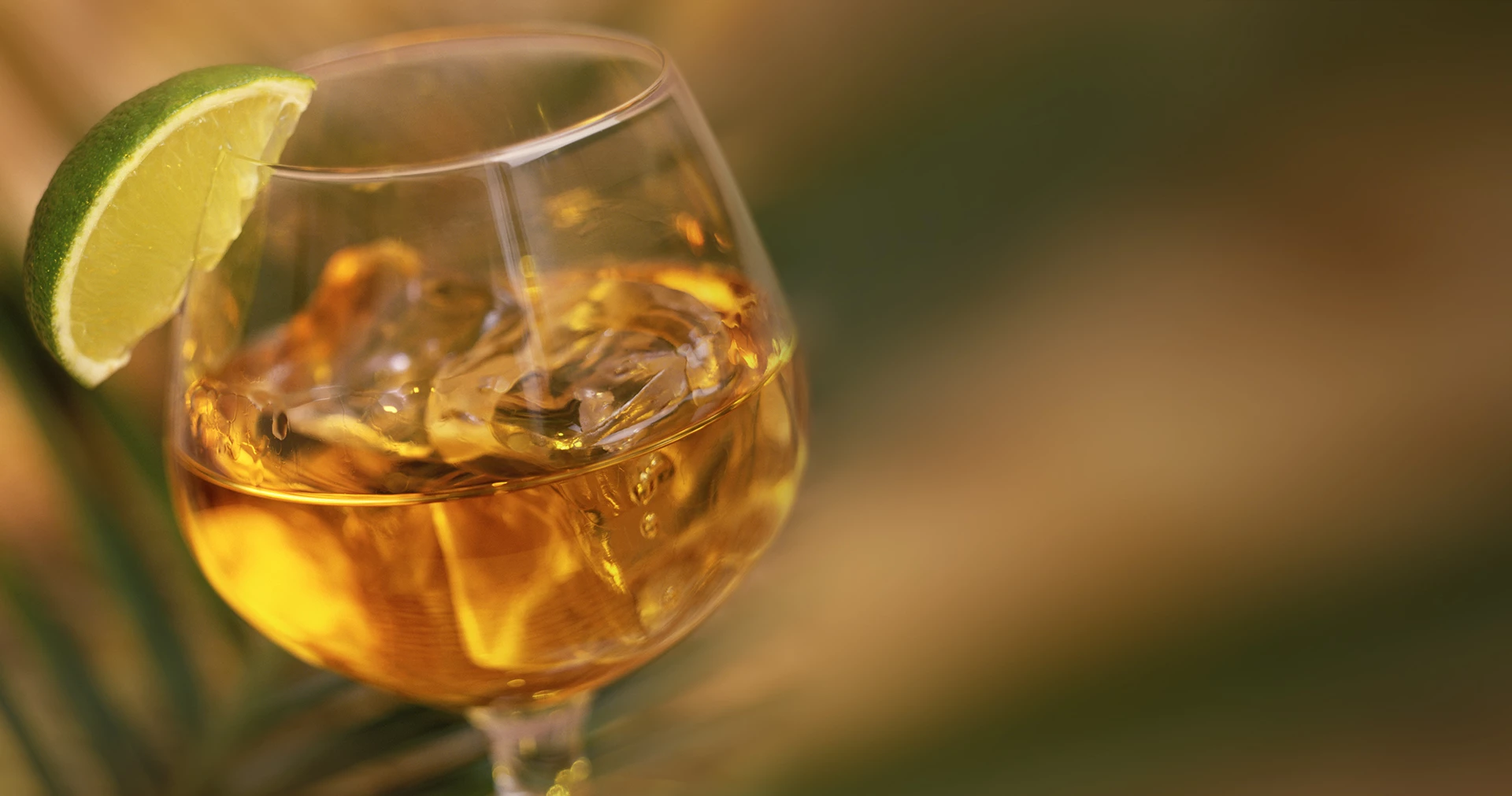 A snifter filled with liquor and garnished with a lime slice.