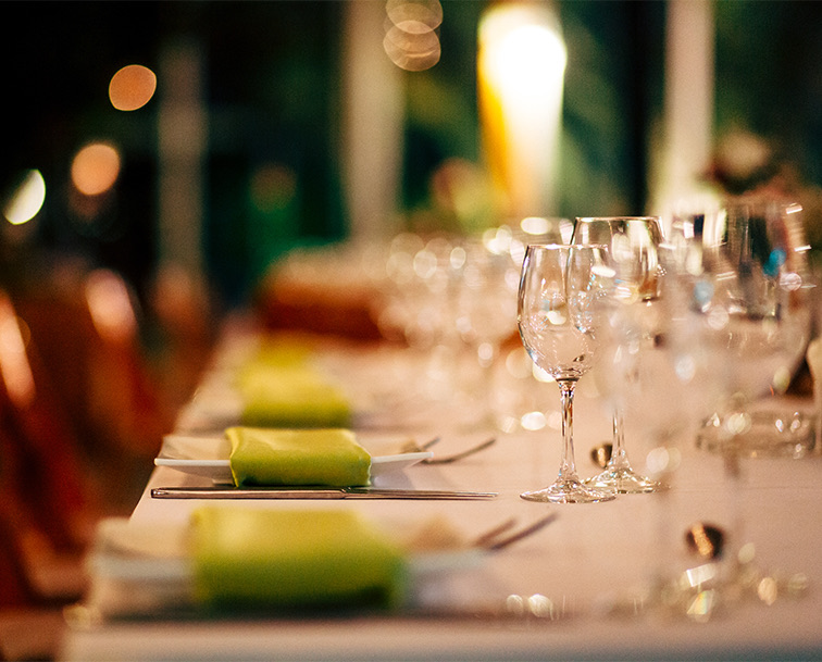 A long table setup for dinner with lime green linens.