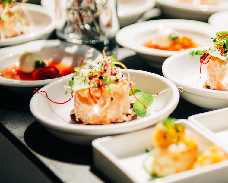 Seafood appetizer served in small white round plates.