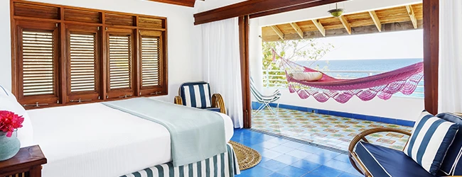 a room with a bed and chairs