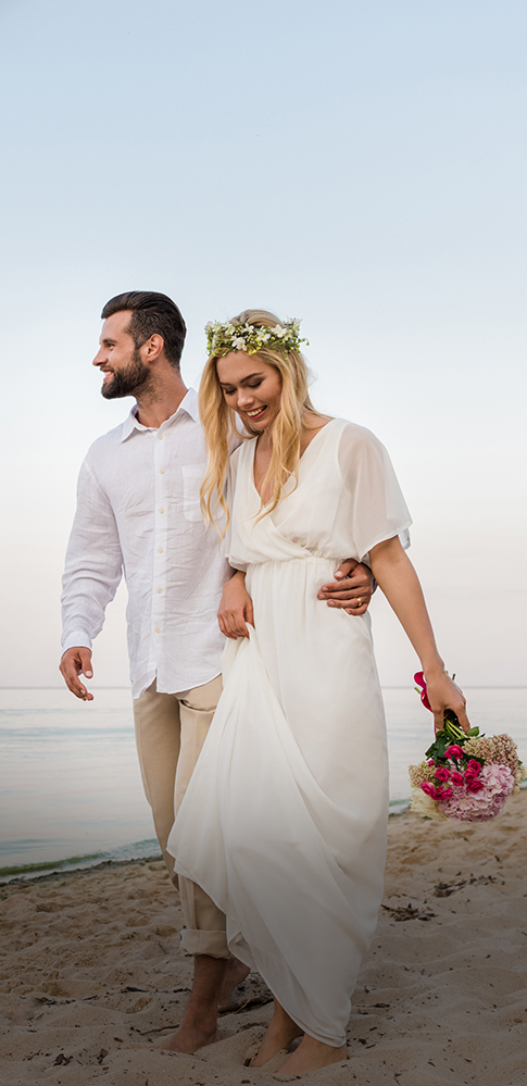 a man and woman walking on a beach