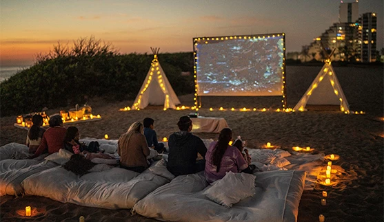a group of people sitting on pillows in front of a screen