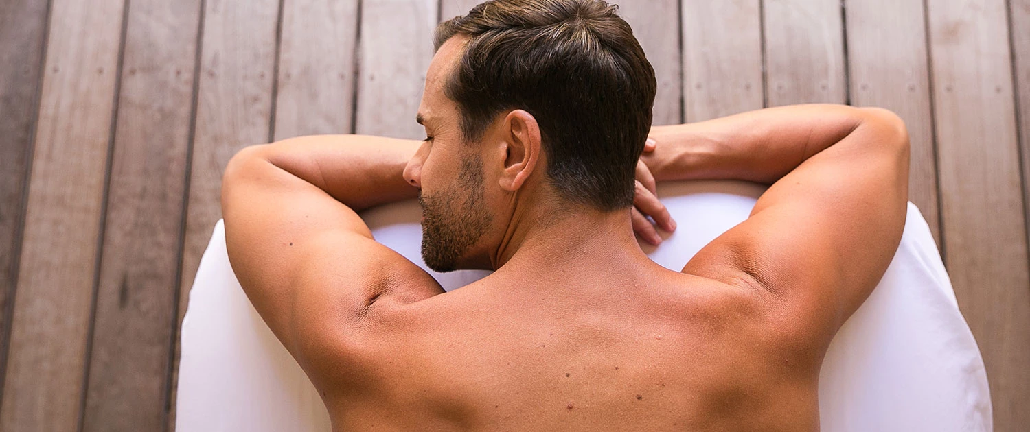a man laying on his stomach on a spa table