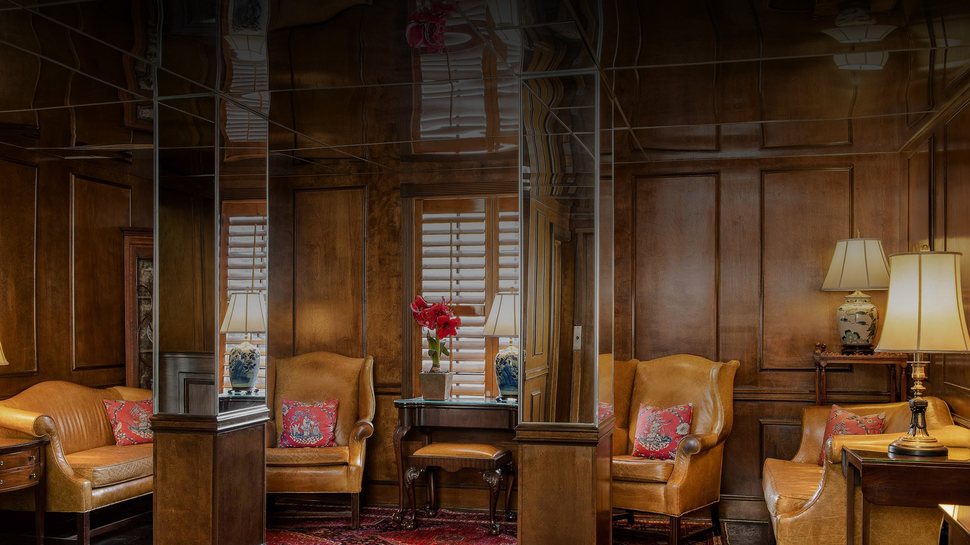 a living room with leather chairs and lamps 