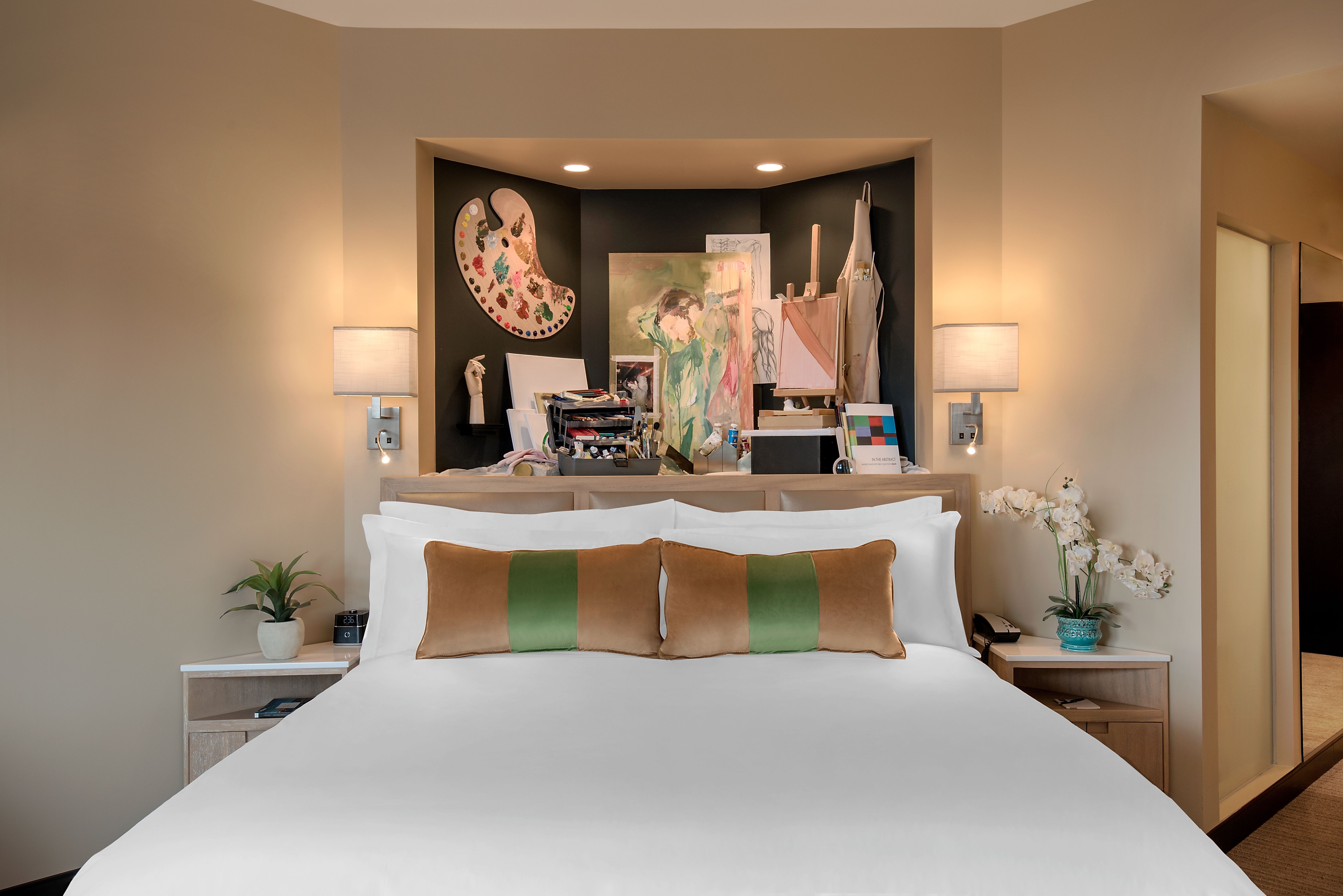 a bedroom with a large painting on the wall