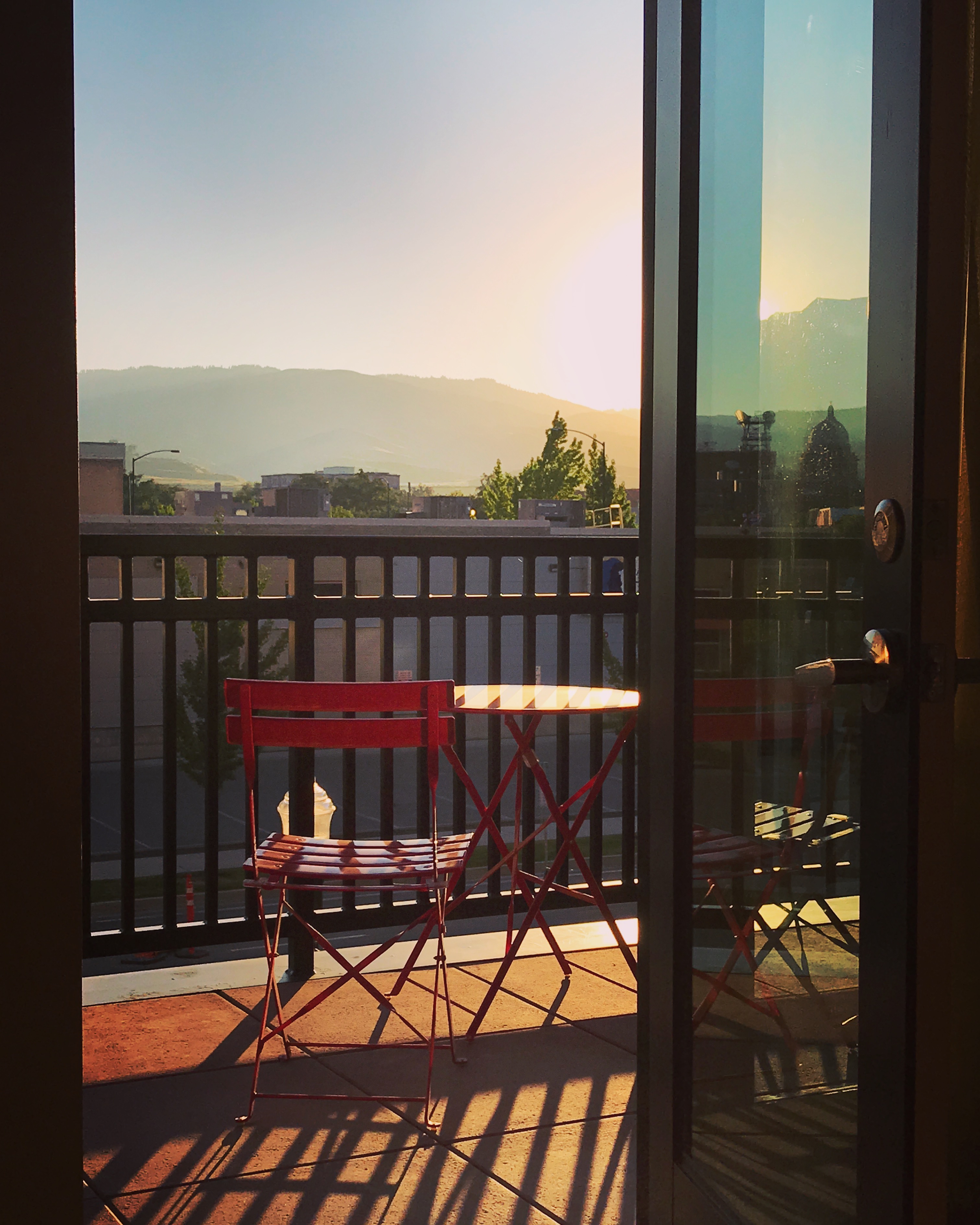 a red chair and table on a balcony