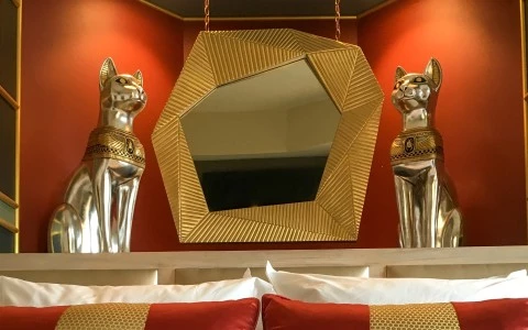 Inn at 500 Capitol Egyptian Theatre-themed guestroom with rich colors and golden decor.