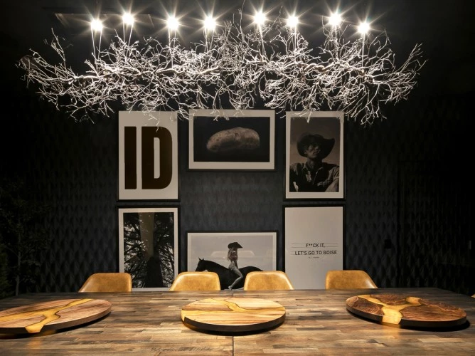 a table with chairs and lights from the ceiling