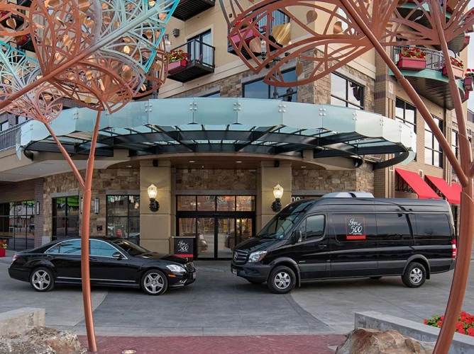 a couple of cars parked outside a building with a large arch