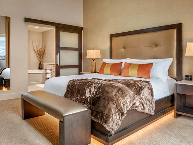 a bed with a bench and lamp