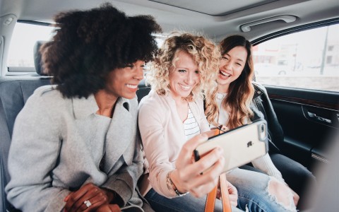 a group of women in a car taking a selfie