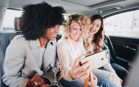 a group of women in a car taking a selfie