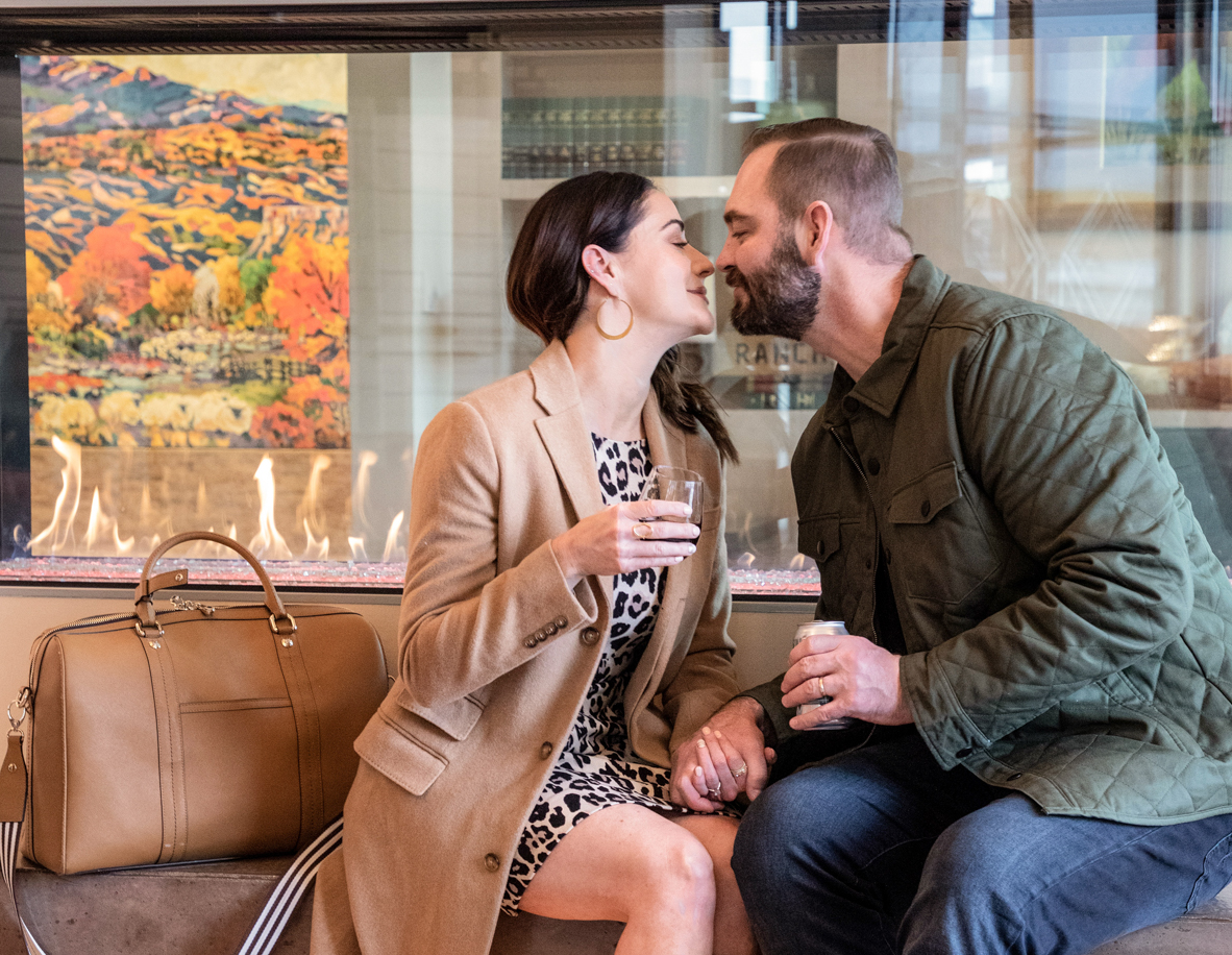 a man and woman sitting on a bench kissing