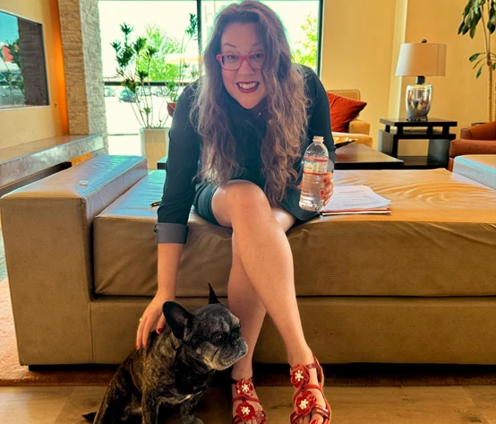 a woman sitting on a couch with a dog
