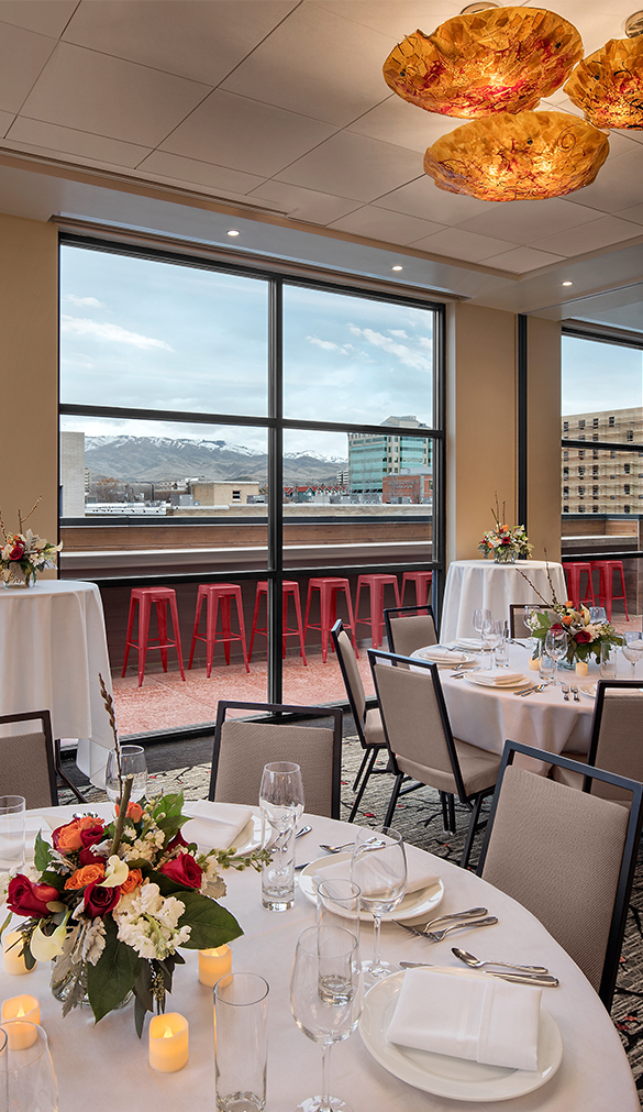 a room with tables and chairs and a view of the city