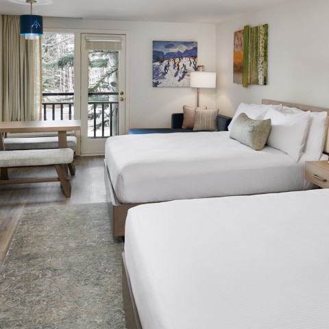 a room with two beds and a table