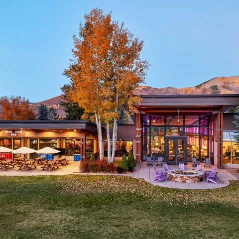 a building with a fire pit and trees
