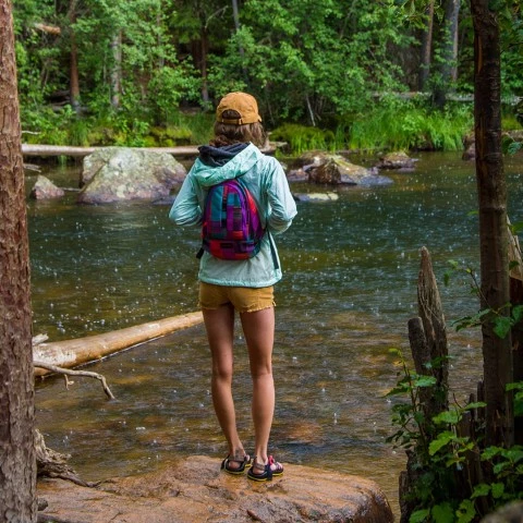 a woman standing on a rock in a river