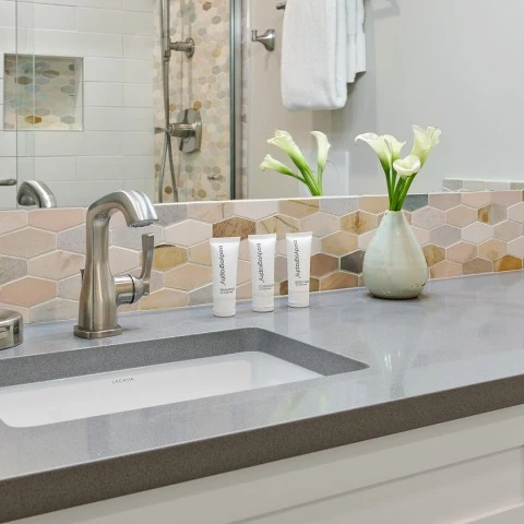 a bathroom sink with a faucet and a vase of flowers