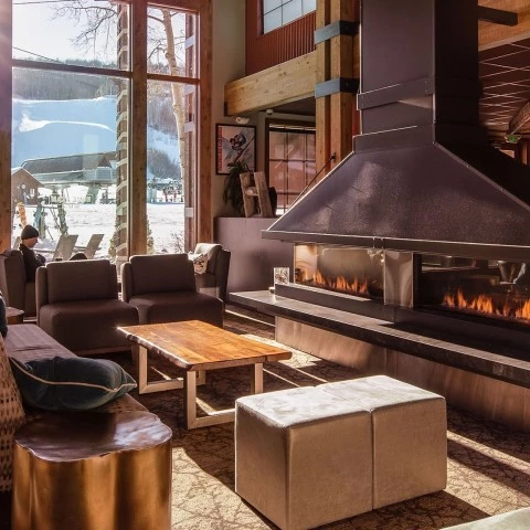 a fireplace in a room with a person sitting in the background