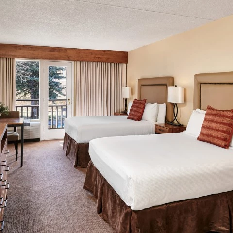 a room with two beds and a table