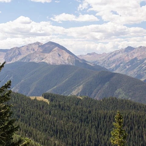 a mountain range with trees and mountains in the background