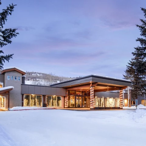 a building with lights and trees in the snow